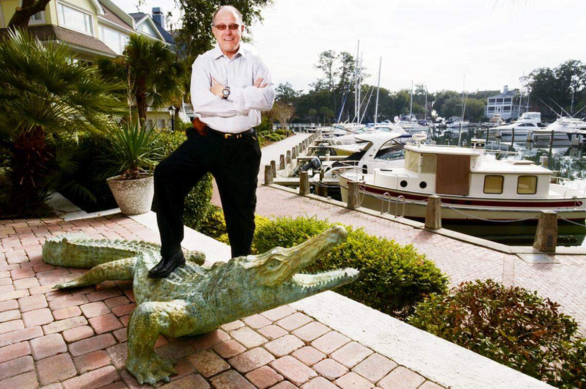 Island businessman Skip Hoagland, mastermind of the Hilton Head Visitor and Convention Bureau, stands by his life-size alligator sculpture outside his Windmill Harbour home on Tuesday.