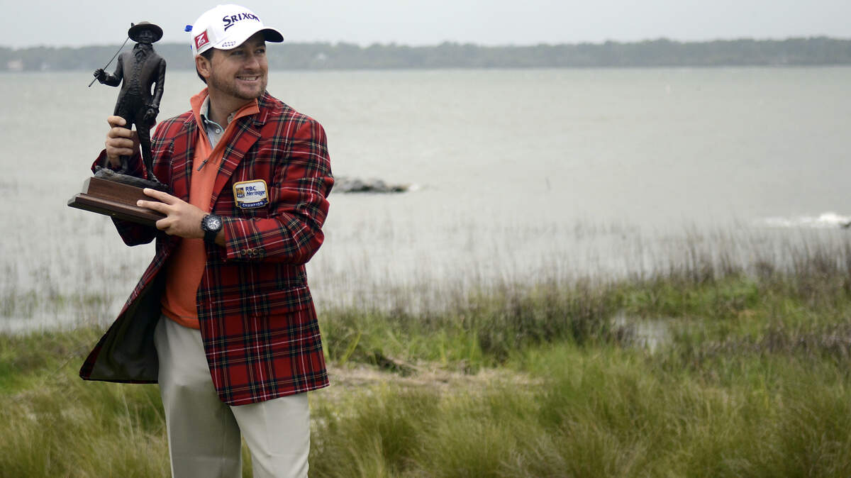 Graeme McDowell poses with his tournament trophy, while wearing the winner's tartan jacket, on the green of No. 18 on Sunday afternoon after the final round of the RBC Heritage Presented by Boeing at Harbour Town Golf Links at Sea Pines on Hilton Head Island, S.C.
