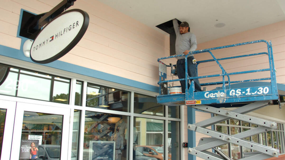 A worker continues preparations for Thursday's reopening of the Tanger 1 Outlet Center in Bluffton. 