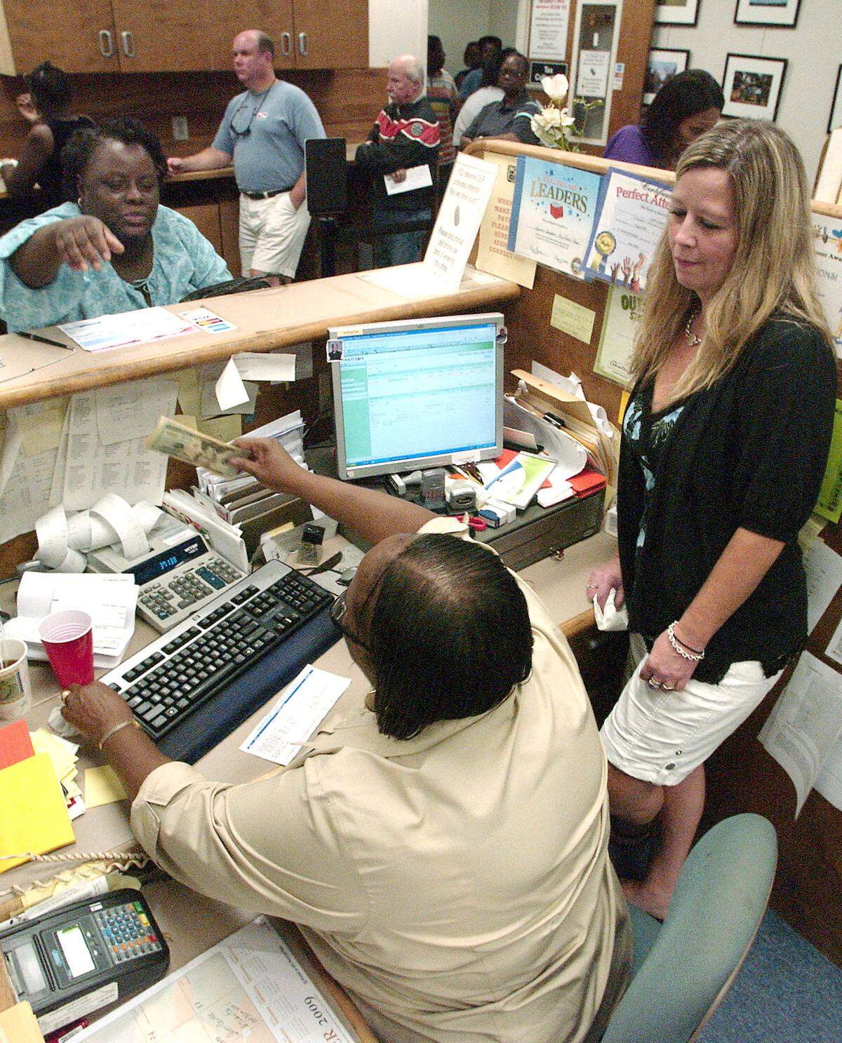 Johnna Neil, right, a Beaufort County delinquent tax agent, helps Lucy Campbell, left, with delinquent tax collection on the last day residents could pay their taxes before the tax sale in 2011. Many in line with other tax related business were caught in long lines.