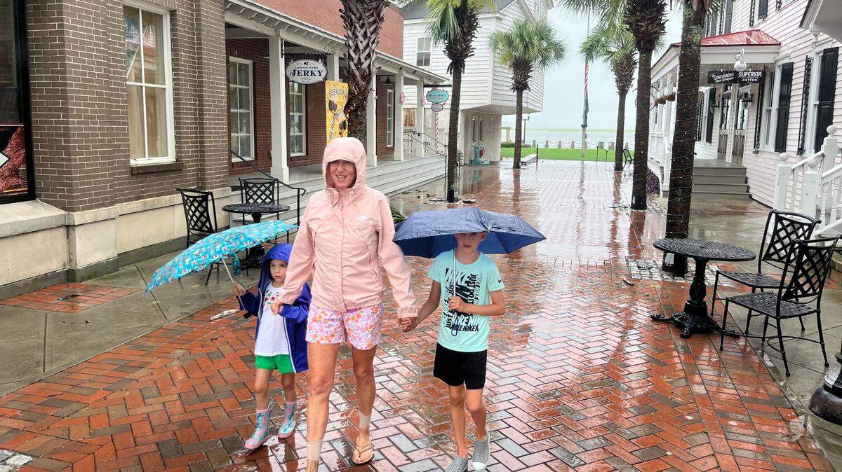 Pam Drafts and her grandchildren, Mason, 4, left, and Brady, 6, walk through the rain in downtown Beaufort on Tuesday morning, Aug. 6, 2024.