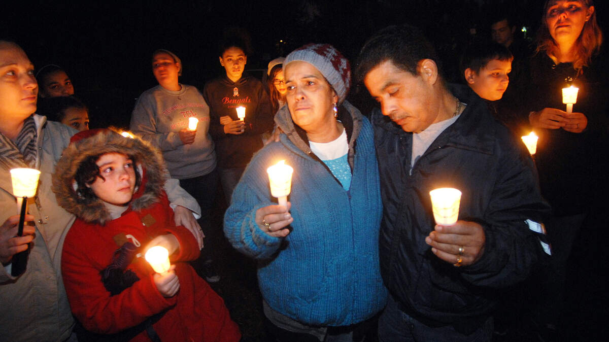 Supporters surround Margaret Degros, center, mother of shooting victim Nicholas Degros, and Degros' uncle, Charlie Negron, during a candlelight vigil for Nicholas, who was killed on Friday night at the corner of Washington and Wilmington Streets in Beaufort. At right is Nicholas' fiancee, Amanda Allen.