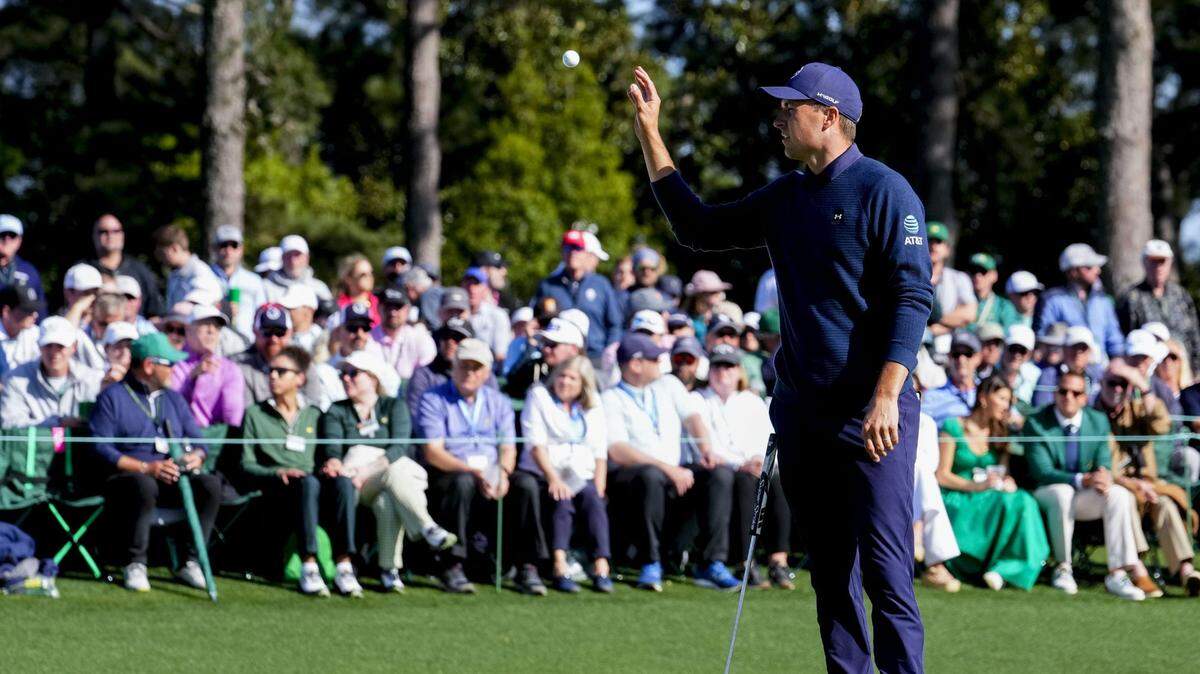 Jordan Spieth catches a ball at the 18th green during the final round of the Masters golf tournament.