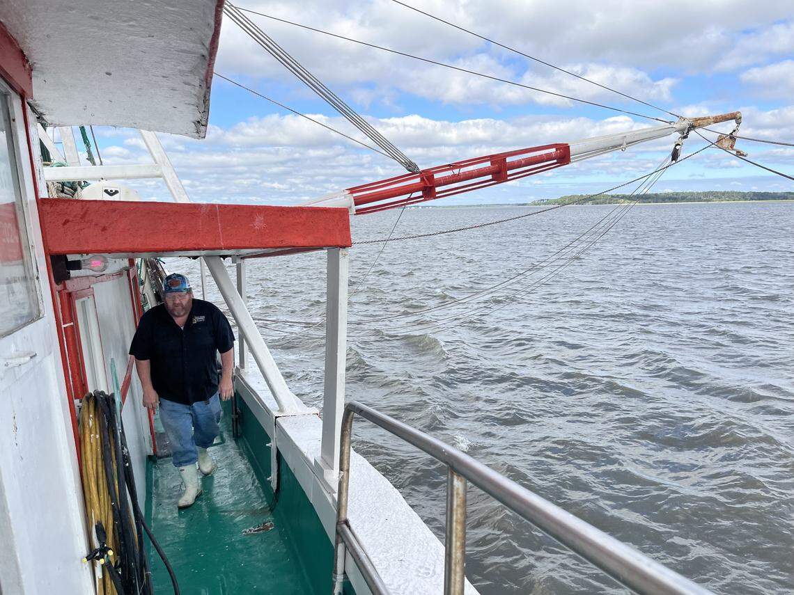 Capt. Craig Reaves makes his way from the rear of the Gracie Belle to the pilot house as his crew prepares the outriggers and nets for a day of fishing for white shrimp on St. Helena Sound.