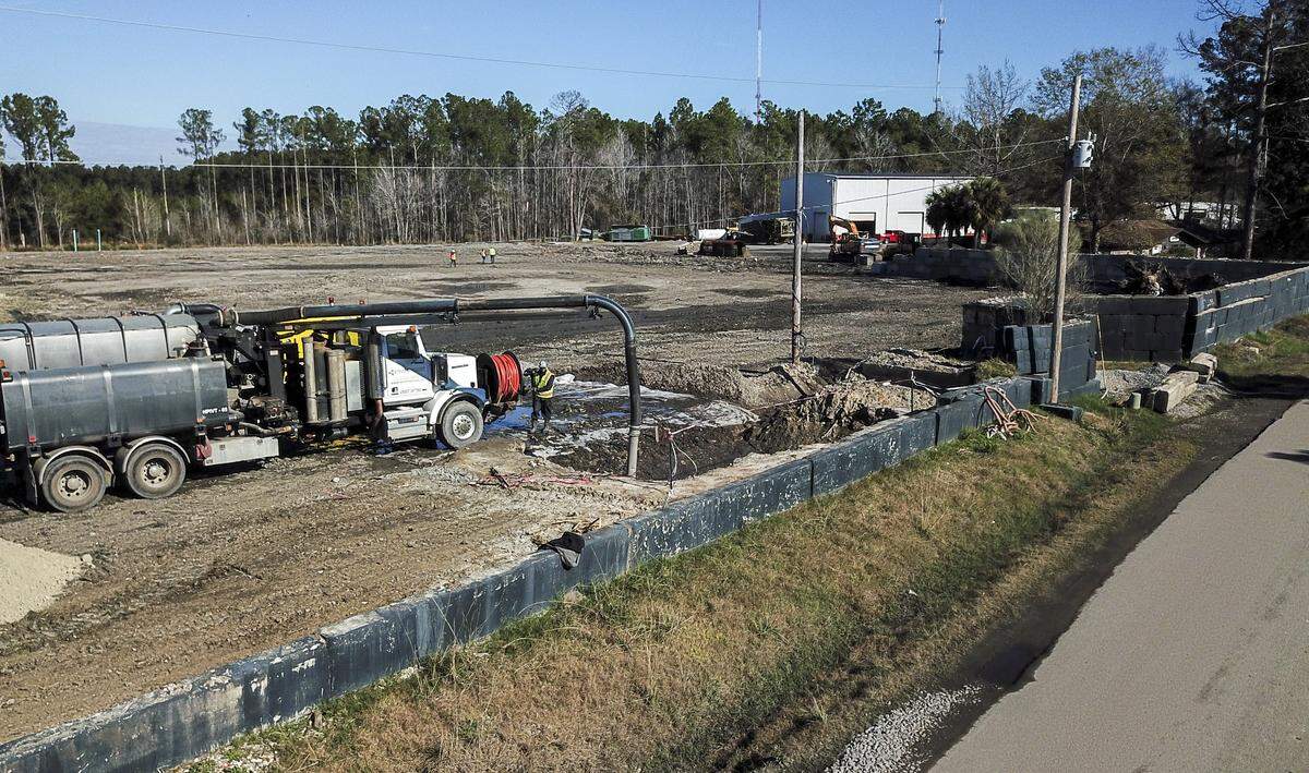 A worker with Envirosmart on Tuesday morning vacuums runoff from the tower of debris that once stood at Chandler Lloyd’s Able Contracting Material Recovery Center in Jasper County. 