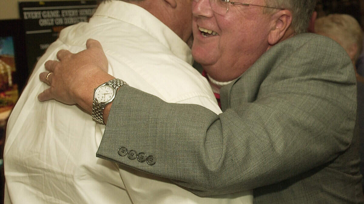 Doug Henderson, right, gets a congratulatory hug Tuesday night at the Cat Island Grill and Pub at the Sanctuary Golf Club.