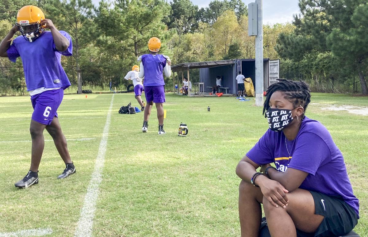 Whale Branch Early College High School athletic trainer Tabria Cochran watches the Warriors football team practice Tuesday evening. Cochran takes players temperatures before practice and asks them a familiar series of questions to screen for coronavirus symptoms.