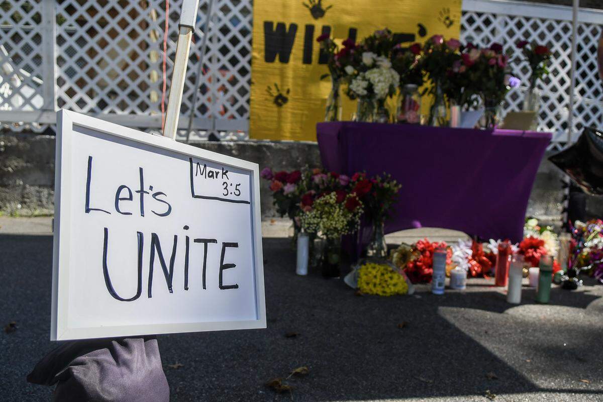 A “Let’s Unite” sign with a bible verse has been added to the memorial outside of Willie’s Bar and Grill on St. Helena Island Oct. 14, 2025, two days after a mass shooting took place outside the establishment. Four people were killed and scores of others were injured. 