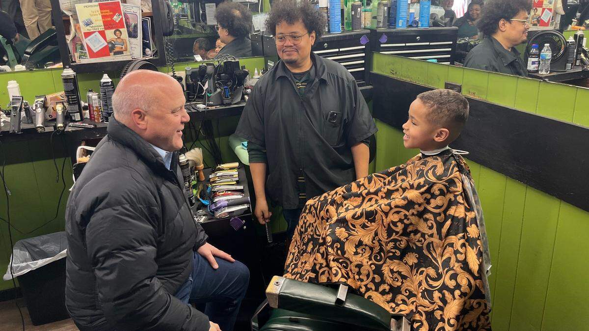Mitch Landrieu, the national co-chair of the Joe Biden-Kamala Harris campaign, greets 5-year-old Braxton Grant and barber David Ferguson at Singleton’s Barber Shop in Beaufort. Democrats are conducting get-out-the-vote rallies across the region in advance of Saturday’s Democratic primary.