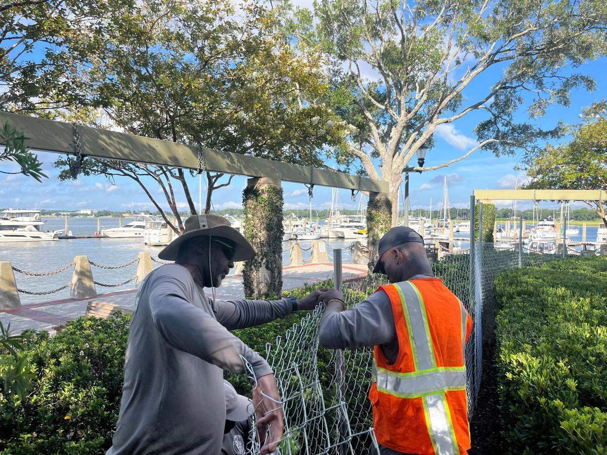 Mel Heru and Wayne Smalls of the city of Beaufort erect a fence along the promenade in Waterfront Park Monday morning. The promenade has structure issues and is being closed indefinitely.