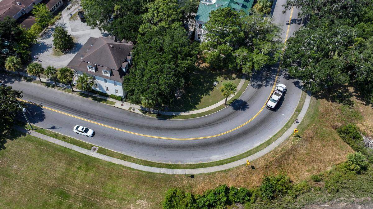 A pedestrian makes their way along the sidewalk that mirrors the 90-degree curve where Carteret Street, left, meets with Boundary Street, known as Bellamy Curve as photographed on Sept. 17, 2025, in Beaufort. In July, officials with the City of Beaufort, Town of Port Royal, USCB and others met with the S.C. Department of Transportation to discuss pedestrian safety. One solution is to paint 24-inch wide, white diagonal stripes on the pavement to calm drivers. Another option is to remove the sidewalk and build an elevated boardwalk positioned farther away from the road’s curve.