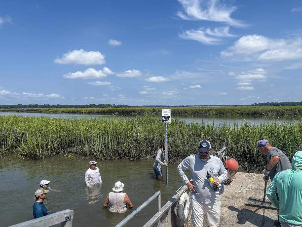 SCDNR staff and volunteers finish unloading manufactured wire reefs into Archers Creek. The effort will help reestablish oyster beds in the creek, which will help hold sediment in place and alleviate erosion.