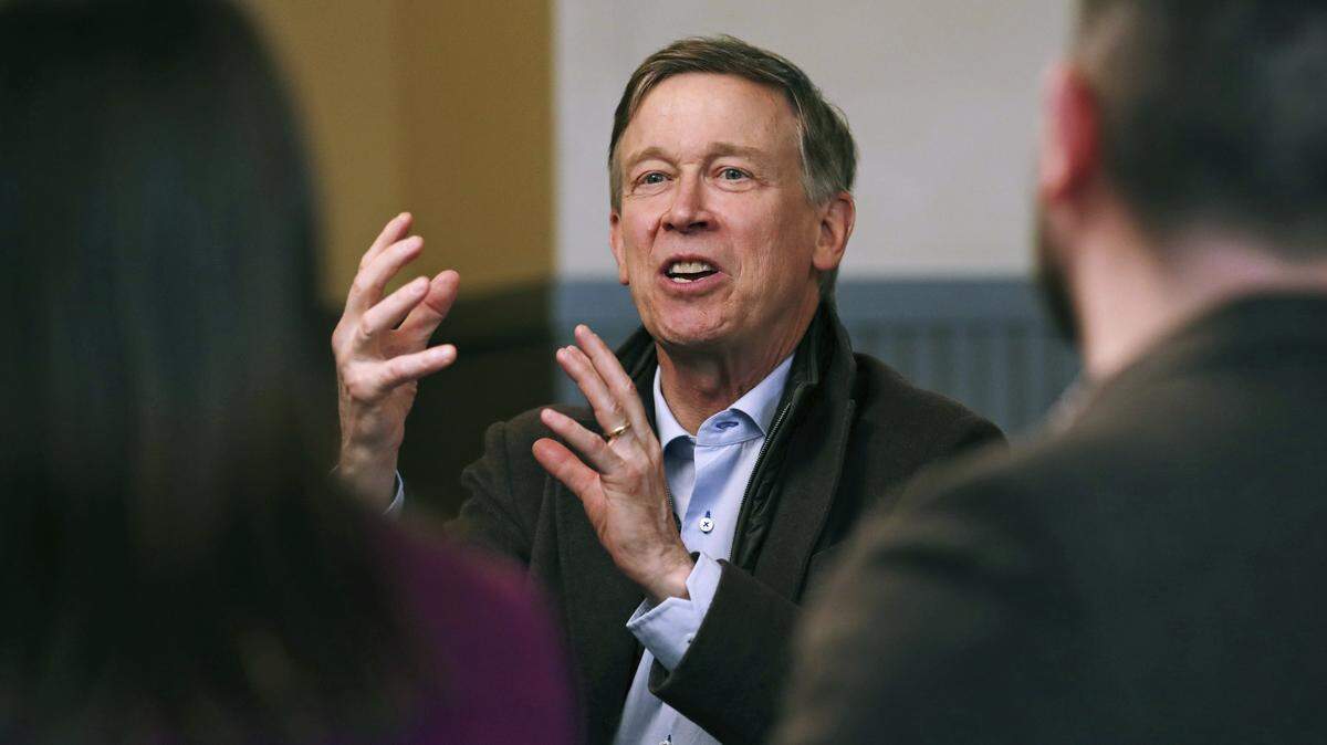 Former Democratic Colorado Gov. John Hickenlooper gestures during a meeting with AmeriCorps members at a roundtable campaign stop in Manchester, N.H., on March 22.