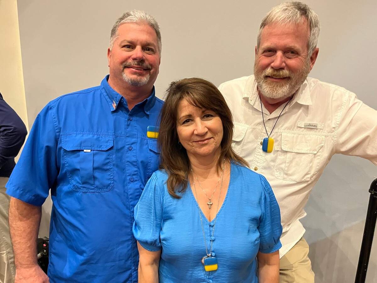Beaufort artists and gallery owners Eric and Mary Thibault, left, and Greg Rawls, also an artist, have teamed up to produce pins and pendents showing the Ukrainian flag that they are selling to raise money for the country that Russian forces invaded Feb. 24. On Monday, they presented a check for almost $11,000 to the City of Beaufort for its fundraising campaign for the Ukrainian city of Ostroh.