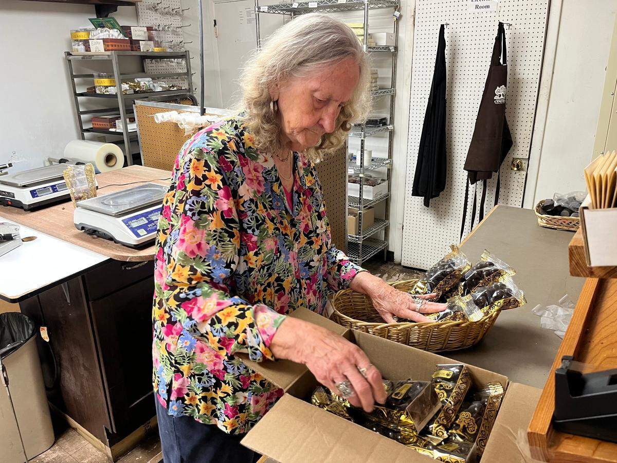Manager Mary Fox gets a basket of candy ready for the shelf at The Chocolate Tree in Beaufort Tuesday. “We’re all sad about it,” she said of the business closing.