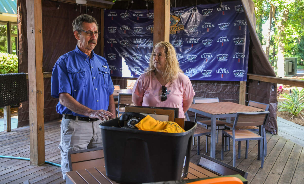 Michael and Jeanne Suminski, Wisconsin residents and long time vacationers to Hilton Head Island, talk on Friday, May 7, 2021, about the box of memorabilia — excluding Green Bay Packer items — associated with the island’s now-closed Jump & Phil’s Bar and Grill. The couple were waiting for John “Jump” Griffin, the former co-owner of the bar, so they could return items to him, including a photo of his father, an old phone and a Jump and Phil’s T-shirt.