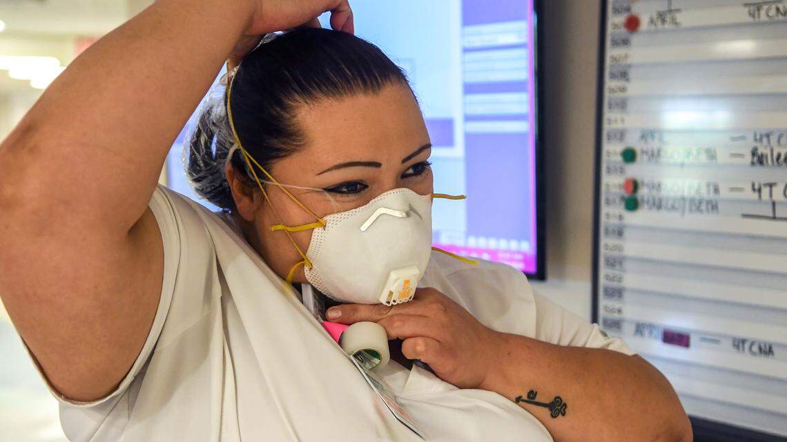 April Simmons-Smith, RN, starts the routine of putting on personal protective equipment that includes a N95 respirator face mask on April 16, 2020 before entering a patient’s room at Beaufort Memorial Hospital.