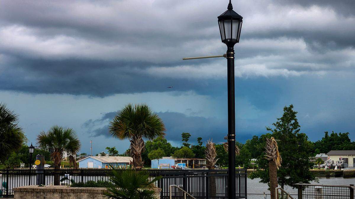 An airplane makes its way to Savannah/Hilton Head International Airport as storm clouds roll in over the Lowcountry as photographed on June 15, 2025, from Eastern Wharf in Savannah, Ga.