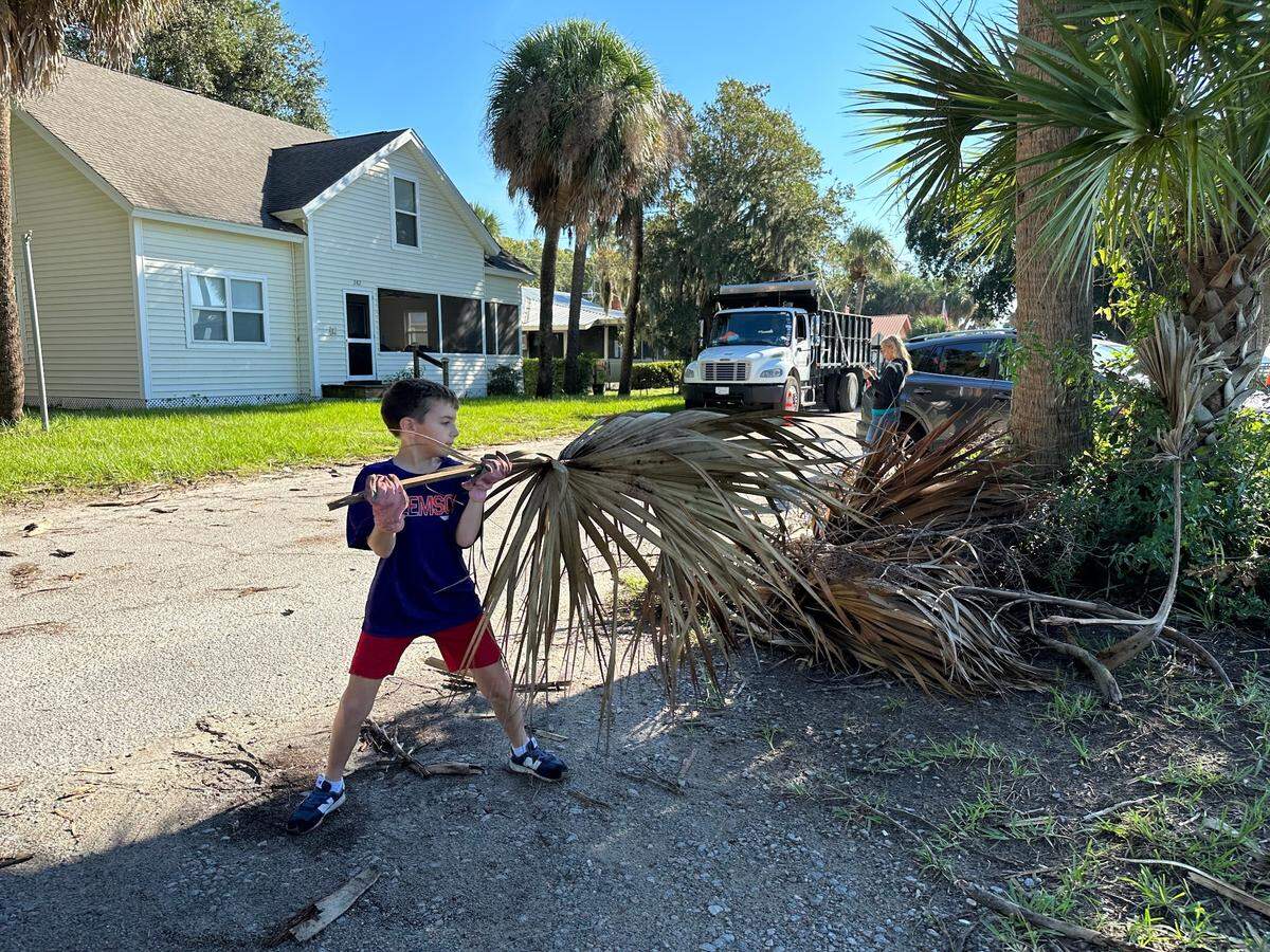 “I did not like that hurricane,” said 8-year-old Harrison McKenzie as he helped pick up nearby palmetto fronds along Alljoy Road, some of which were larger than himself.
