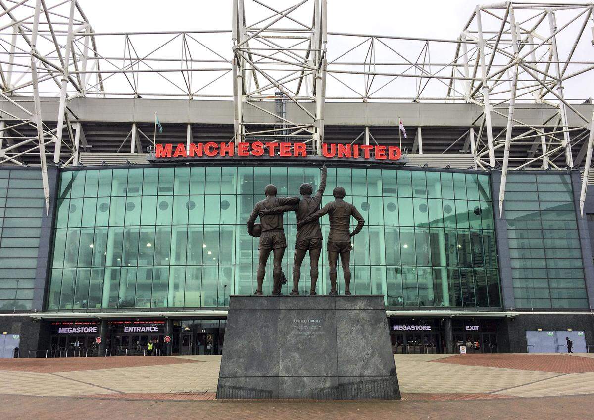 Manchester United’s Stadium, Old Trafford, as seen in March 2017. The statue of the club’s “holy trinity,” Sir Bobby Charlton, George Best and Denis Law, stands at the edge of the stadium.