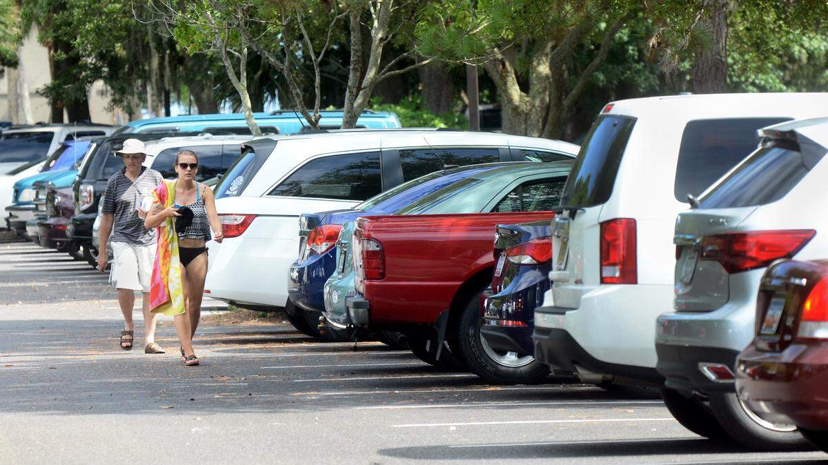 Beachgoers walk through the crowded Coligny Beach public parking lot July 15, 2014. The Hilton Head Island Town Council considered opening a gravel lot next to the Pope Avenue parking lot but decided the action was too expensive to tackle halfway through the season.