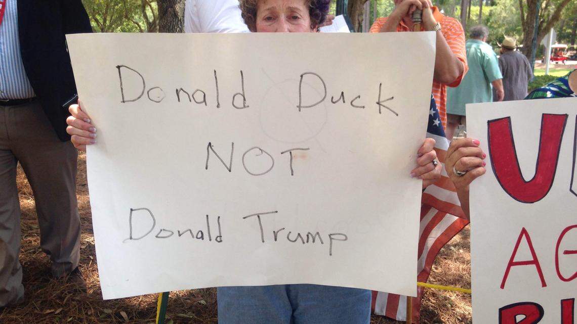 Gerri Heilbraun holds a sign her husband, Stephen Korz, made for the Lowcountry Immigration Coalition's silent protest outside Donald Trump's speech Tuesday afternoon in Sun City Hilton Head.