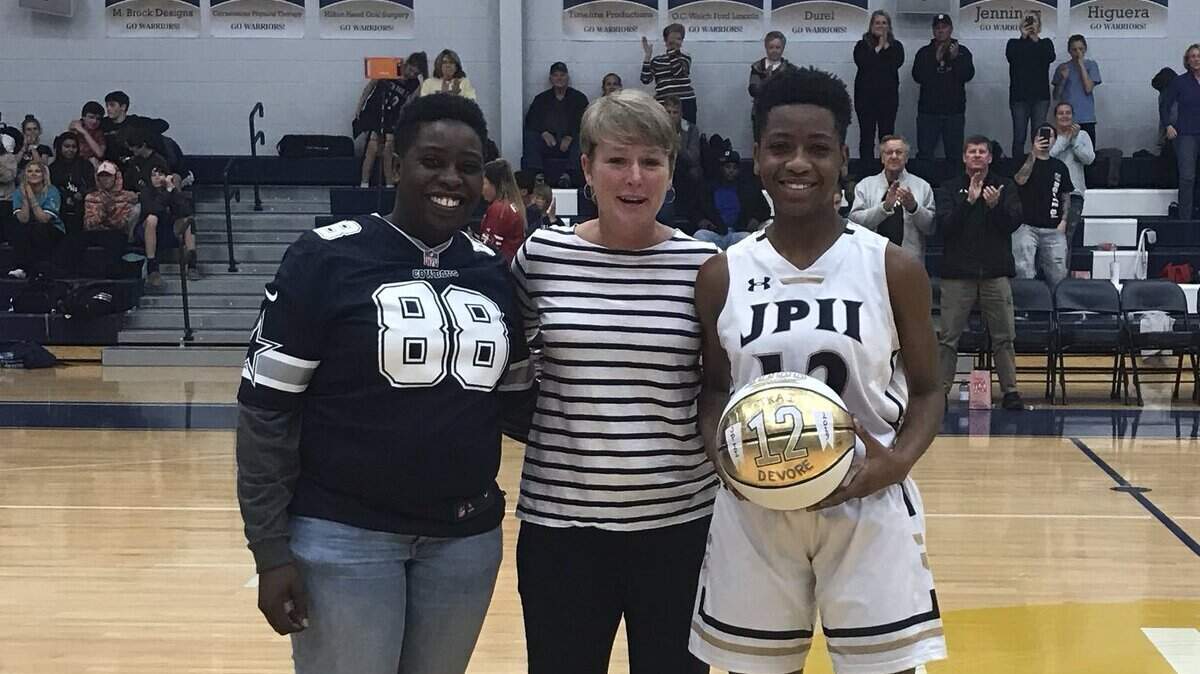 John Paul II’s Tkai Devore is honored for scoring her 1,000 point of her career.