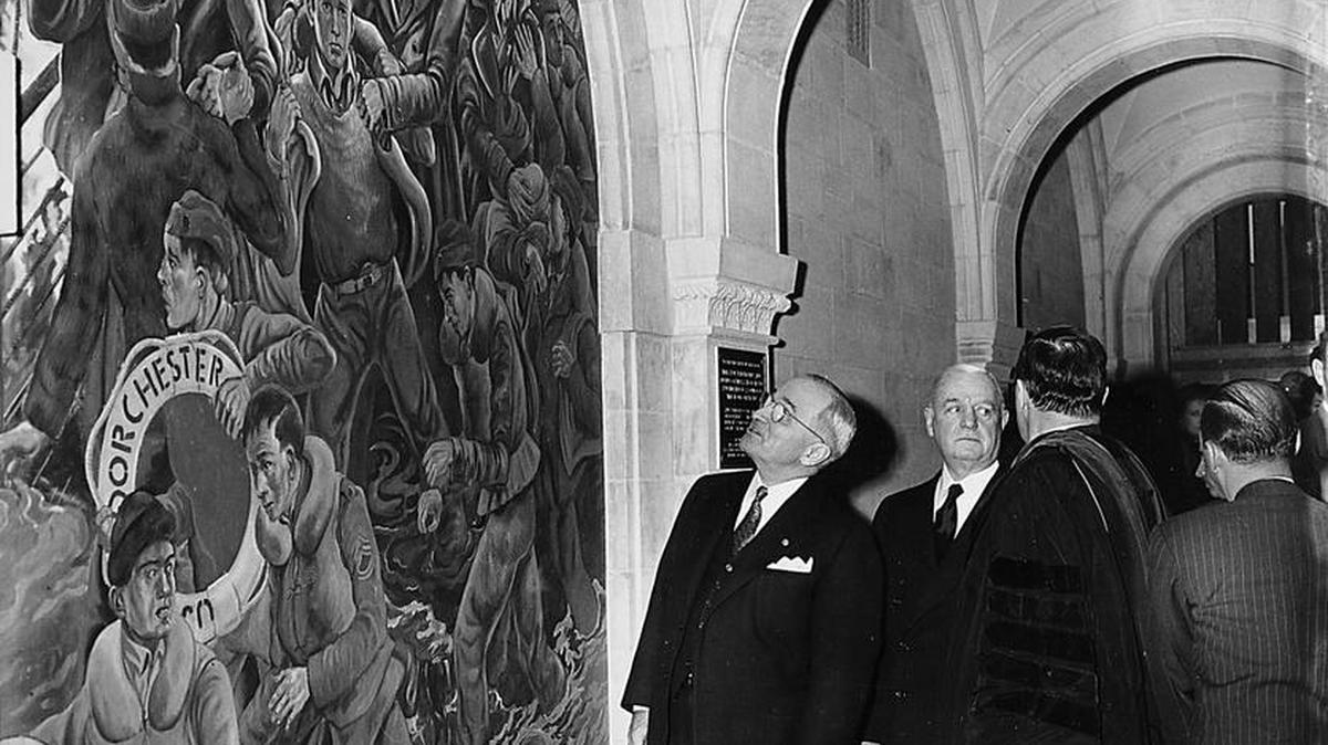 U.S. President Harry Truman looks at a mural before a brief ceremony on Feb. 3, 1951, to dedicate the Four Chaplains Chapel, located in lower church of the Baptist Temple of Philadelphia, Pa. The mural in the Chapel honors four heroic chaplains who gave their lifeboats to others and died aboard the troopship USS Dorchester when it was hit by a torpedo in the North Atlantic in 1943. With the president are Gen. William J. “Wild Bill” Donovan, and the Rev. Daniel Poling, his back to camera, pastor of the chapel and father of one of the hero chaplains.