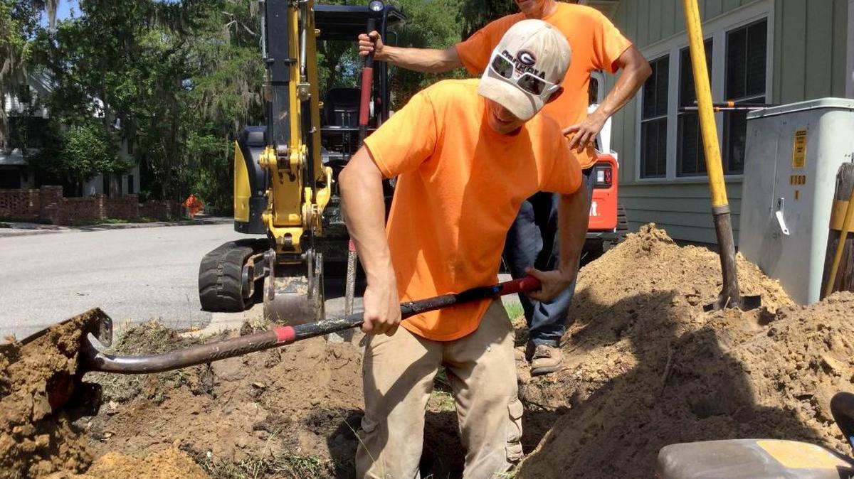 Weymon Bennett digs a hole at the corner of Bridge Road and Calhoun Street in Bluffton while coworker Richard Truett watches on June 15, 2016. Bennett and Truett work for Cape Fear Utilities, which has been contracted by Time Warner Cable to install cable line in the town. Cape Fear Utilities project manager Bill Turner estimated his crew had laid about 2,500 feet of cable.
