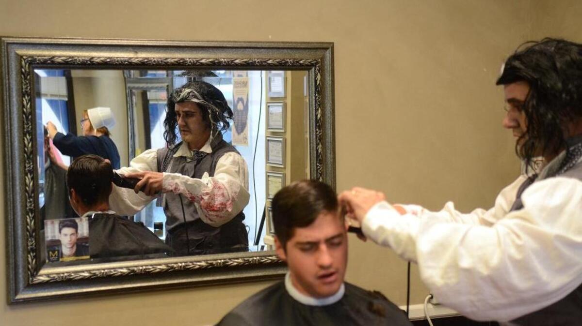 Brent Nelsen, co-owner of Barbers of the Lowcountry, cuts Jordan Arriola's hair dressed as Sweeney Todd, the Demon Barber of Fleet Street on Tuesday morning at their shop in Bluffton.