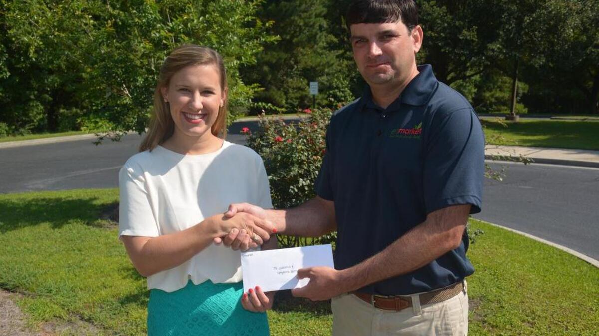 Houstoun Demere, right, of Enmarket presented a check for $91,530 to Sarah Grubbs of the Leukemia & Lymphoma Society. These funds were raised through the May fundraising efforts of the convenience store chain. Since starting this annual fundraising campaign five years ago, Enmarket has donated $332,265 to the nonprofit.