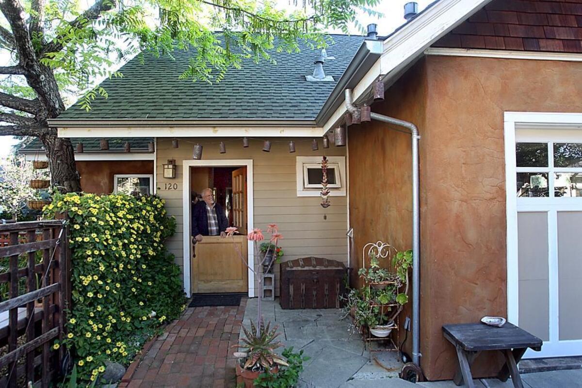 In this April, 2015 photo, David Foster looks at his accessory dwelling unit behind his home in Santa Cruz, California.