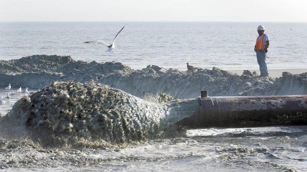 A worker watches as a mixture of sand and water spews from the end of the dredge pipe during a 2007 beach renourishment project on Hilton Head Island.