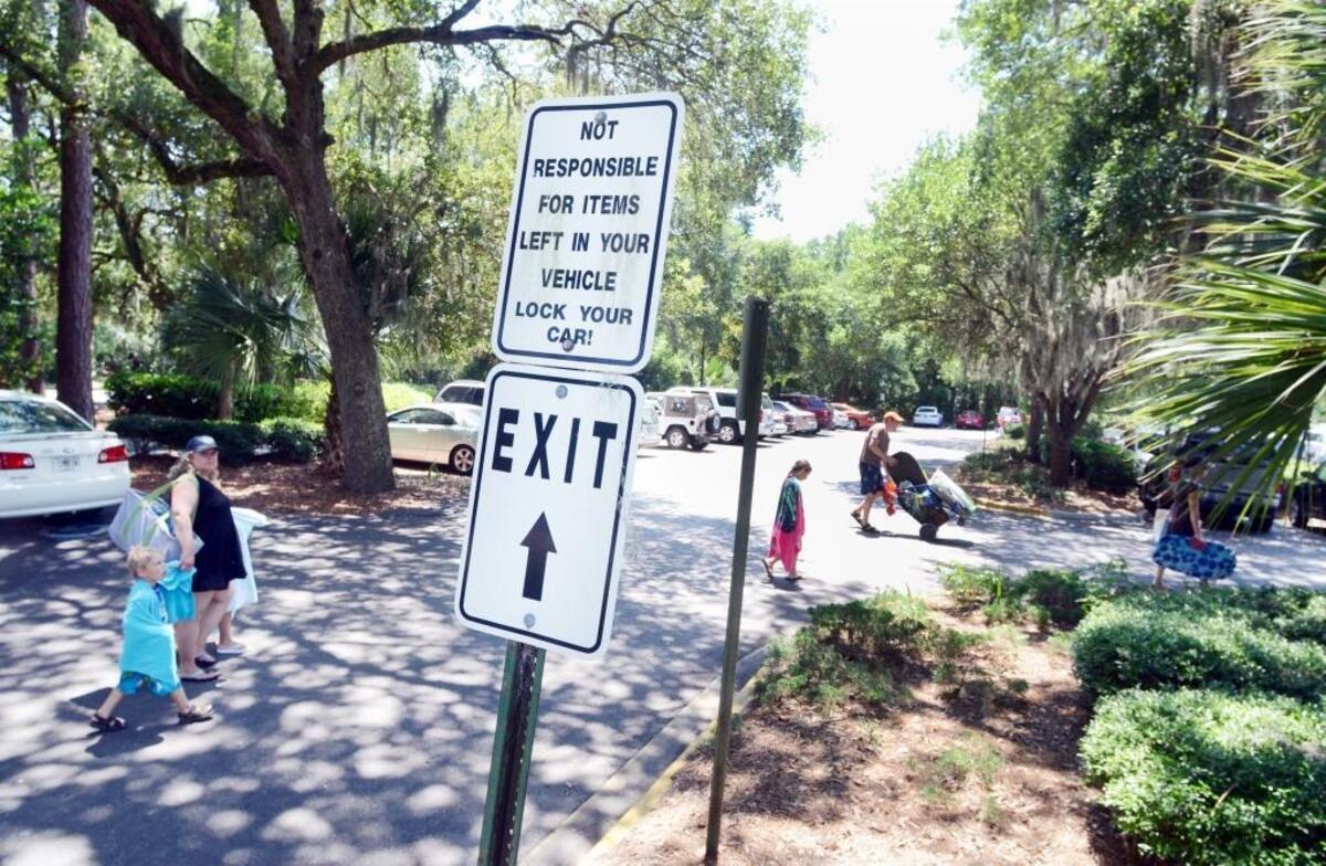 Beachgoers walk across the Coligny Beach parking lot on Hilton Head Island. Parking in the lot is currently free, but town officials are talking about the possibility of charging for beach parking across the island.