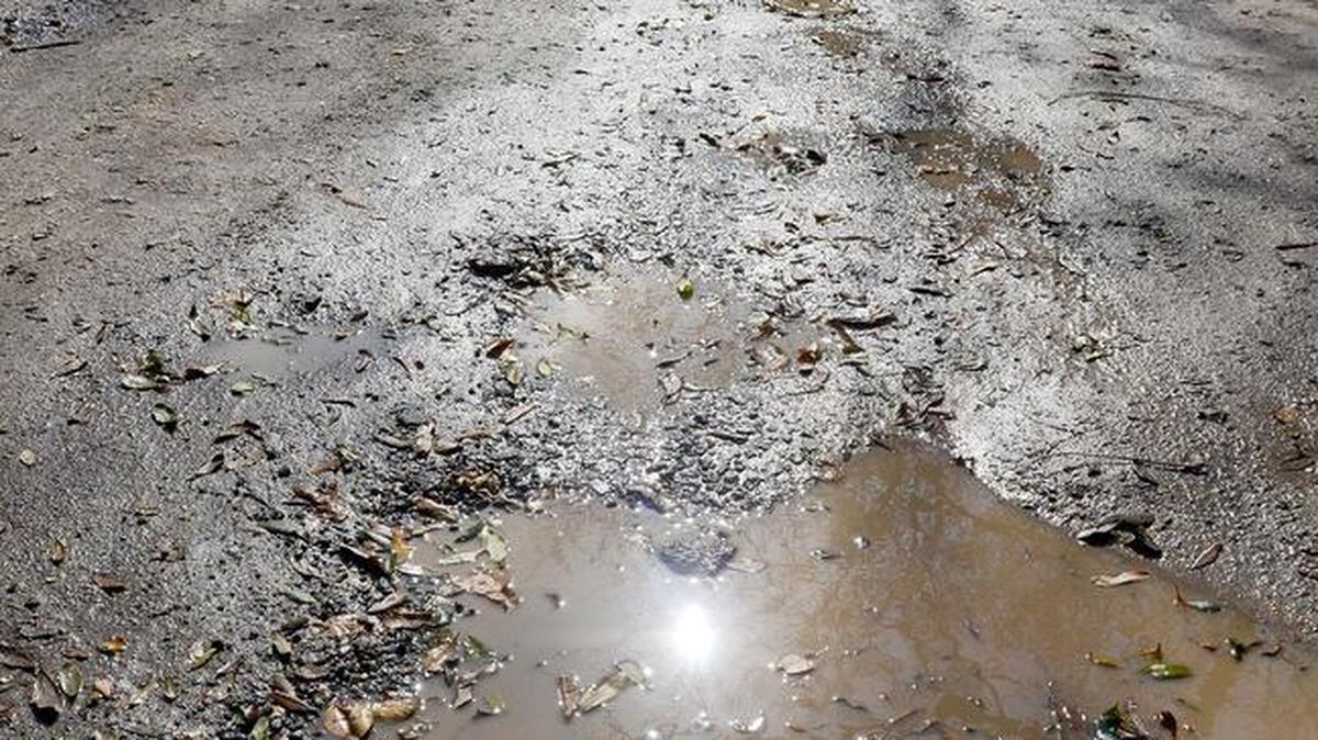 A car works its way down the pothole-ridden and puddle-filled Blazing Star Lane on Hilton Head Island in 2016. 