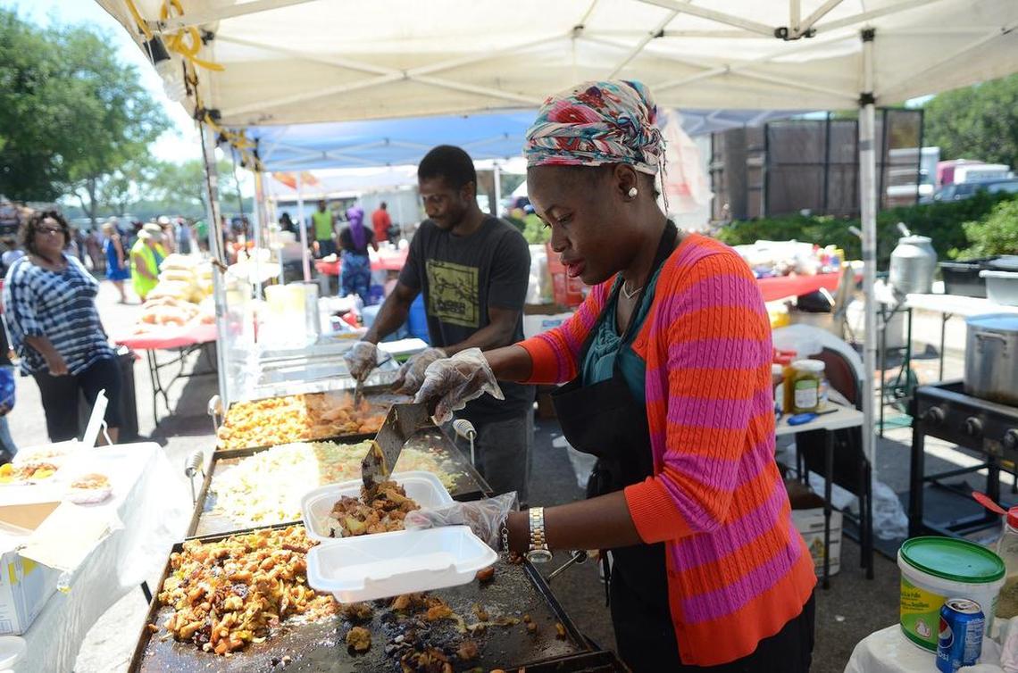 Feyi Funke, an employee of Taste of International out of Atlanta, scoops food from their flat grill into a container for a customer during the 31st annual Gullah Festival on Saturday at Henry C. Chambers Waterfront Park in Beaufort.