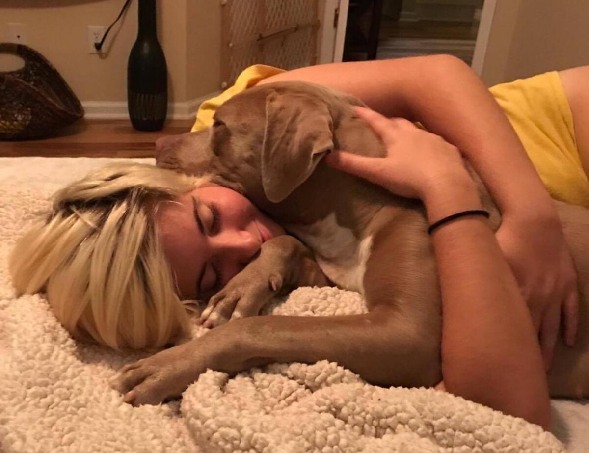 Naomi Gosdin snuggles hugs her rescue pitbull Twinkie. Twinkie is being trained to cuddle up to Naomi during PTSD episodes.