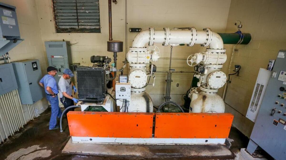 In this file photo from 2016, Beaufort Jasper Water Sewer Authority personnel remove a battery from an auxiliary engine on the pump station in a Bluffton-area development during a major power outage caused by Hurricane Matthew. With no electricity to the pump, crews had to manually pump the station to keep it from overflowing.