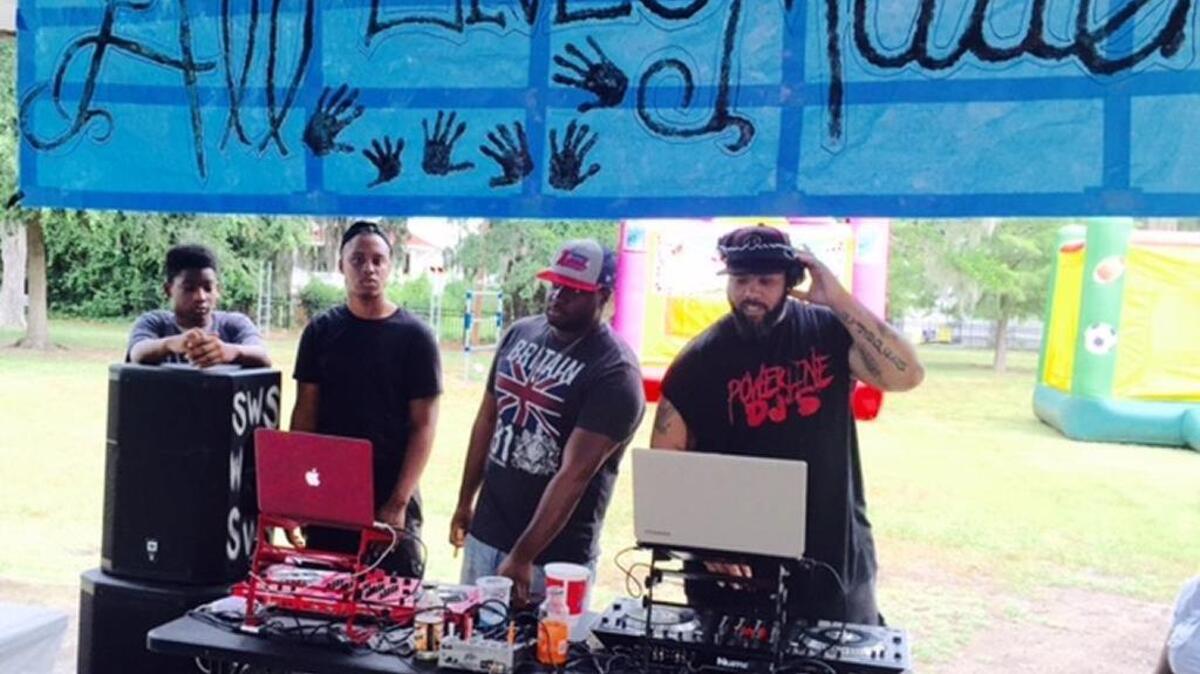 DJs play music under a banner reading “All Lives Matter” during a community event Sunday in Beaufort's Washington Street Park. Police and residents mingled at the event, one of several planned to engage the city’s young people.
