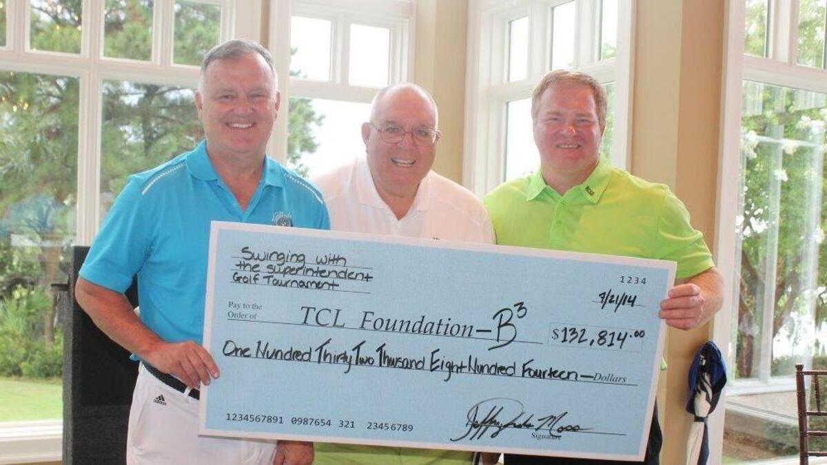 From left, Technical College of the Lowcountry President Richard Gough, former Beaufort County school board chairman Bill Evans and district superintendent Jeff Moss pose with a check for about $132,814, raised in the inaugural Swinging with the Superintendent Scholarship Golf Tournament in 2014.