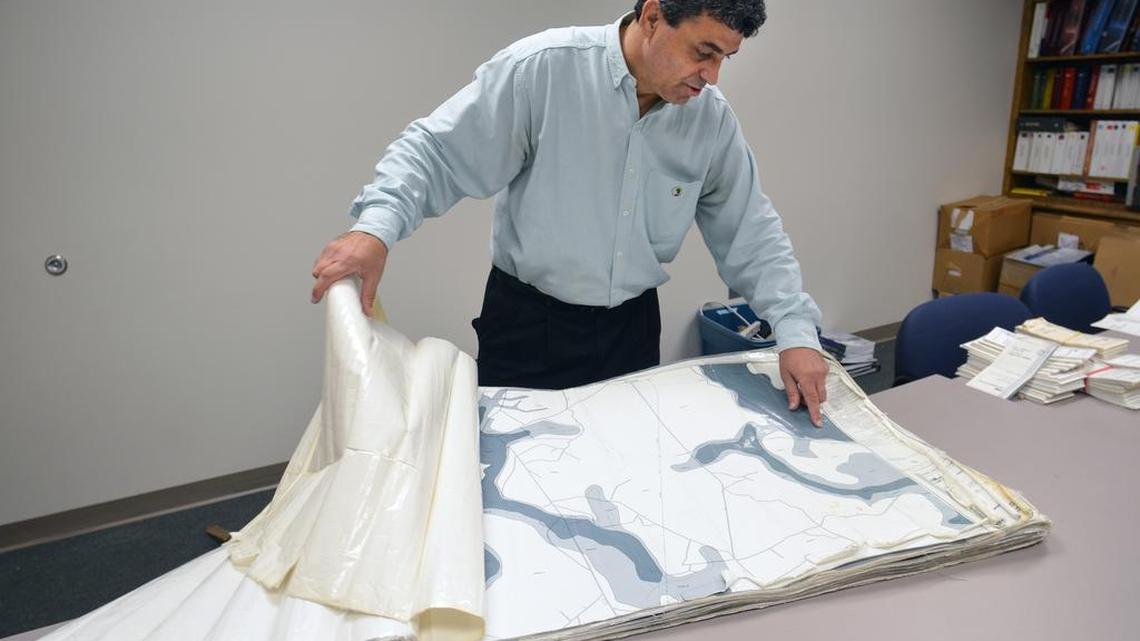 Hakim Bayyoud, Beaufort County's floodplain manager, leafs through a well-worn copy of the county's 1986 floodplain map in his office at the Beaufort County administration building on Oct. 4, 2016.