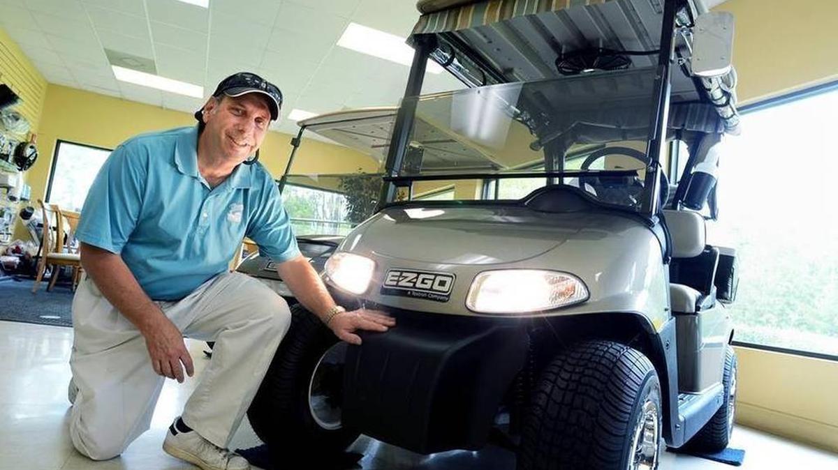 Bob Sutter, of Lowcountry Golf Cars, shows off an E-Z-GO golf cart equipped with headlights at the Okatie dealership.