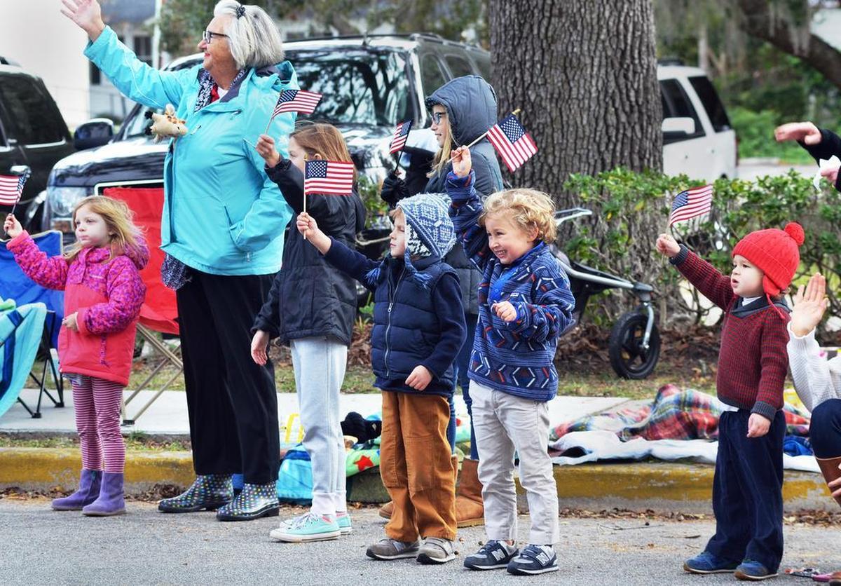 Children wave their flags as the Beaufort Veterans Day Parade heads down Carteret Street on Saturday.