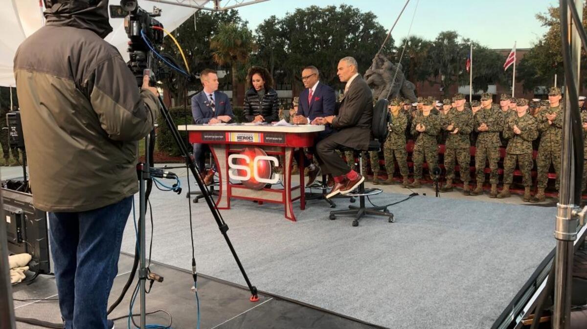 ESPN SportsCenter anchors Randy Scott, from left, Sage Steele and Jay Harris are joined on the Parris Island set by NFL analyst Herm Edwards as Marine recruits watch on Friday morning.
