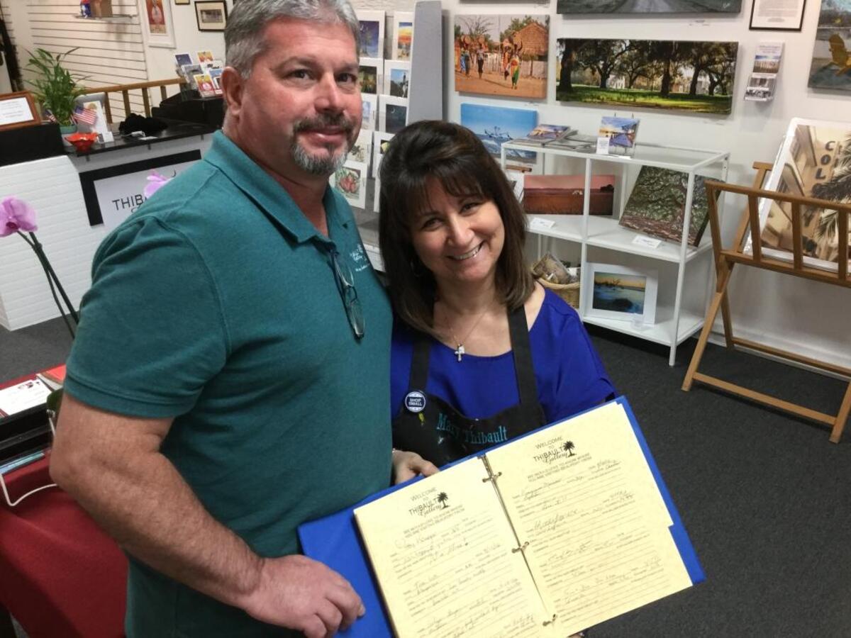 Eric and Mary Thibault pose April 18, 2016, with the Thibault Gallery guestbook on Bay Street in Beaufort. They discovered a signature that appears to be that of pop/country singer Taylor Swift in the book after a visit the previous week.