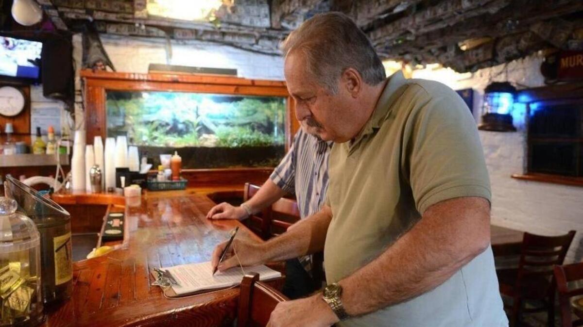 Ed Patrucco, of Lady's Island, signs a petition in support of Hemingway's on Feb. 20, 2017, in downtown Beaufort.