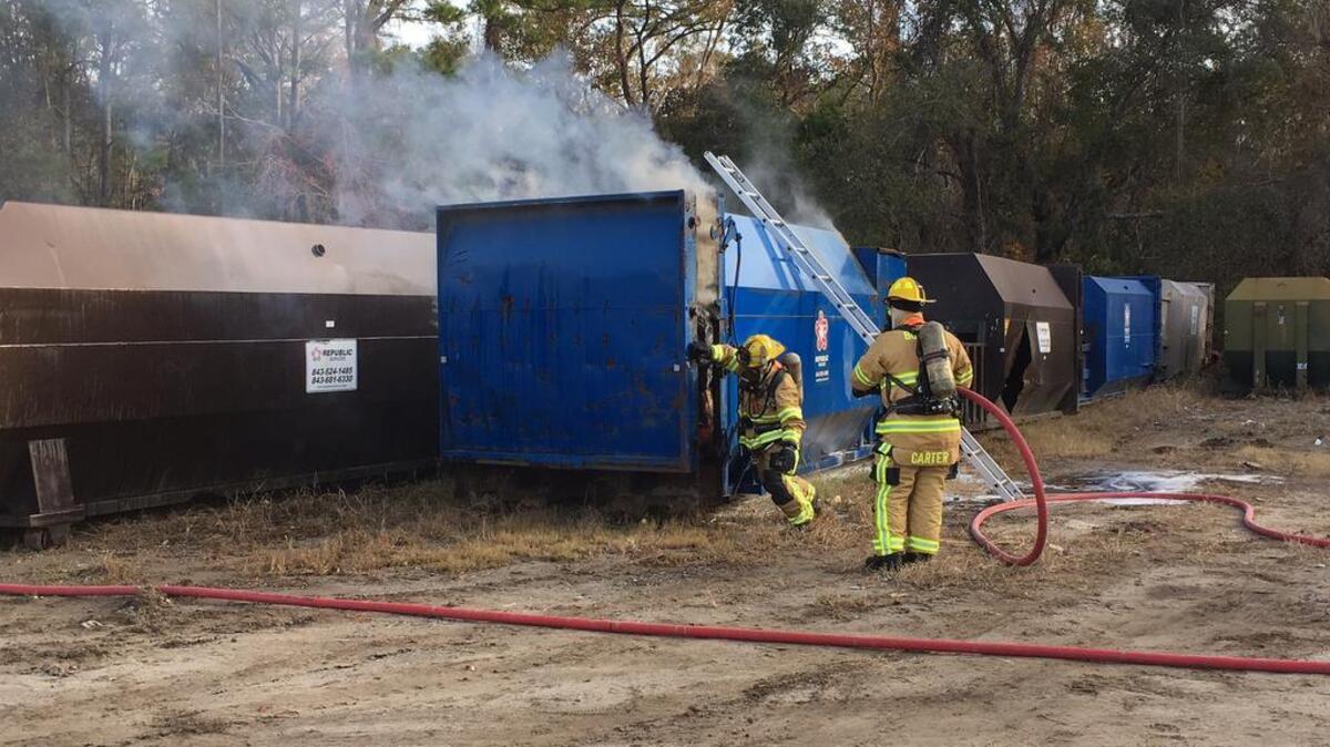 Burton Fire District firefighters approach a dumpster fire near Shell Point on Dec. 16, 2016. After Republic Services employees emptied the trash compactor’s contents on the ground, firefighters sprayed about 2,000 gallons of water over it to squelch the fire.