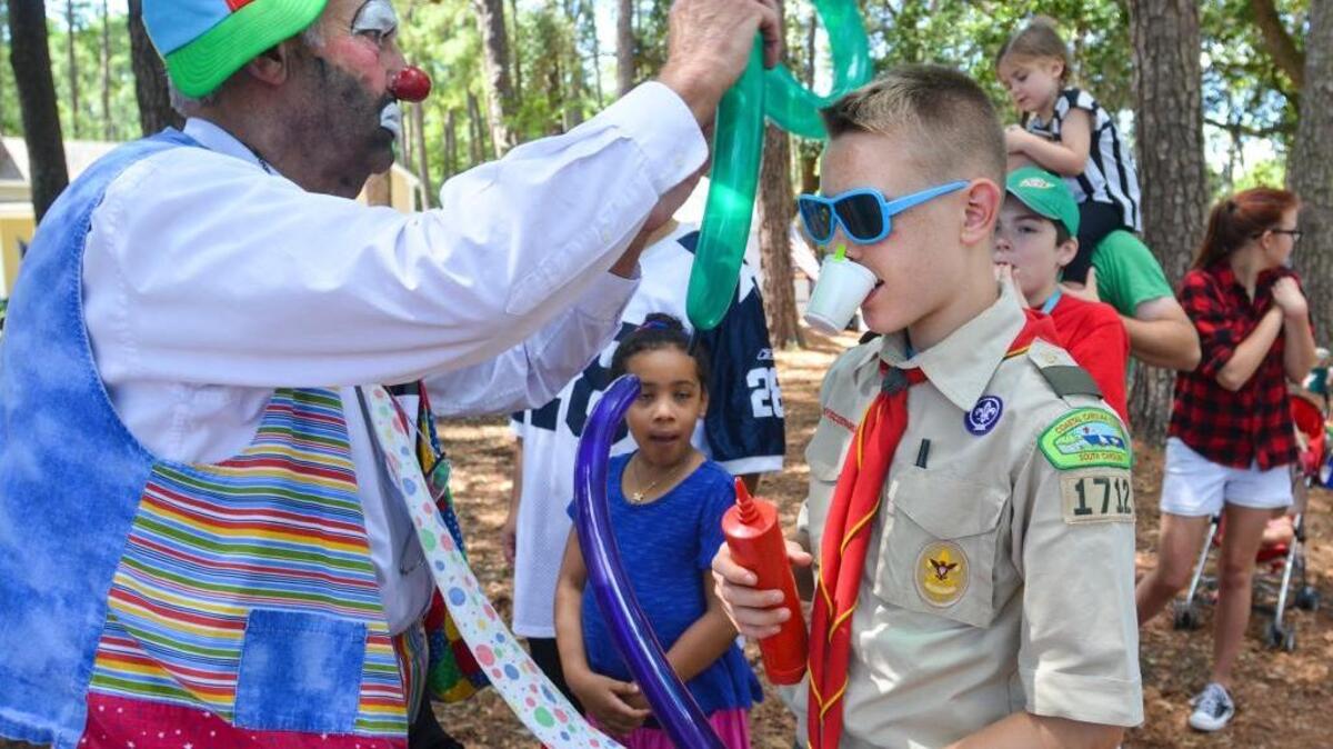 Tux the clown provides Hunter Hughes, 14, of Beaufort with a balloon helmet, shield and sword during the annual Military Appreciation Day on Saturday. “I’m going to go beat up my other fellow Boy Scouts,” said Hughes after he was fully equipped with the necessary balloon armament.