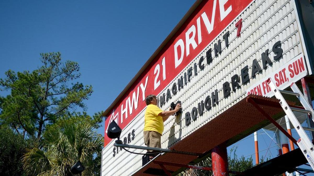 Joe Barth, co-owner of the Hwy 21 Drive-In, changes the movies listed on their sign on Friday, September 30, 2016, at the Hwy 21 Drive-In in Beaufort. “This is the job that no one likes to do, but someone has to do it.”