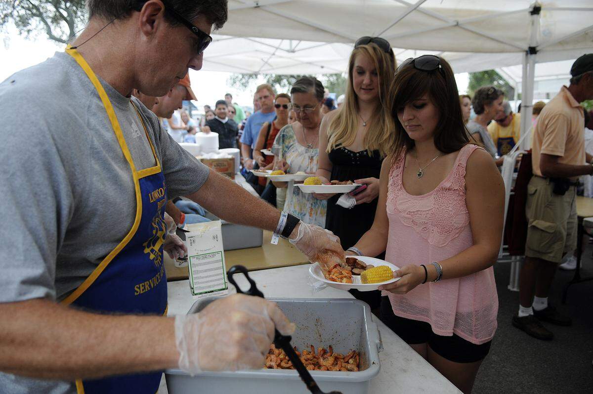Doug Crowley with the Lowcountry Rotary Club serves shrimp to Maria Bartholf of Ridgeland during a previous Lowcountry Supper.